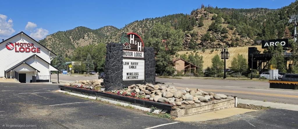 The H&H Motor Lodge sign and buildings on Colorado Boulevard, with the canyon hillside rising behind them.